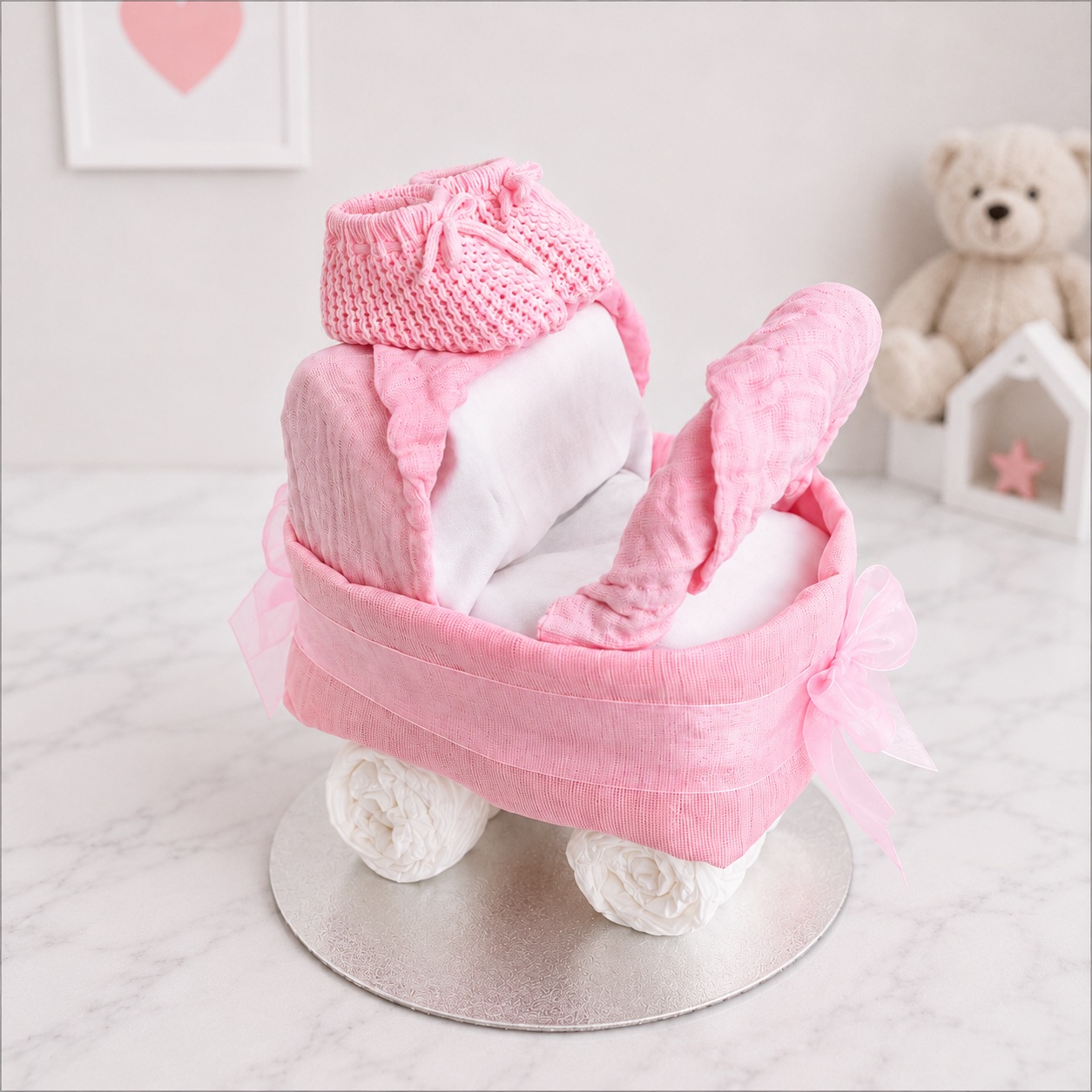 Side view of the pink pram nappy creation showing the nappy wheels and pink detailing