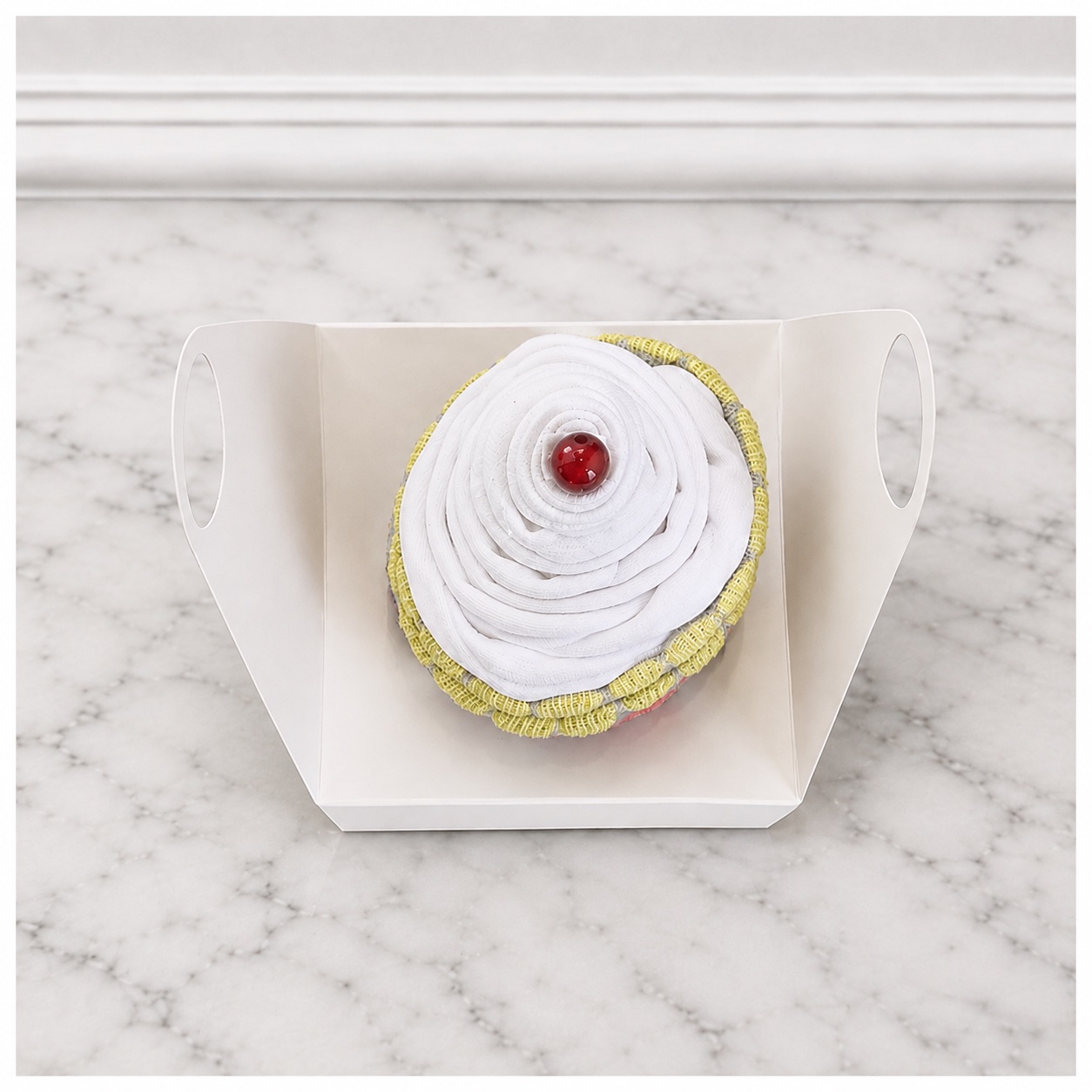 Top-down view of the grey baby cupcake in a white gift box