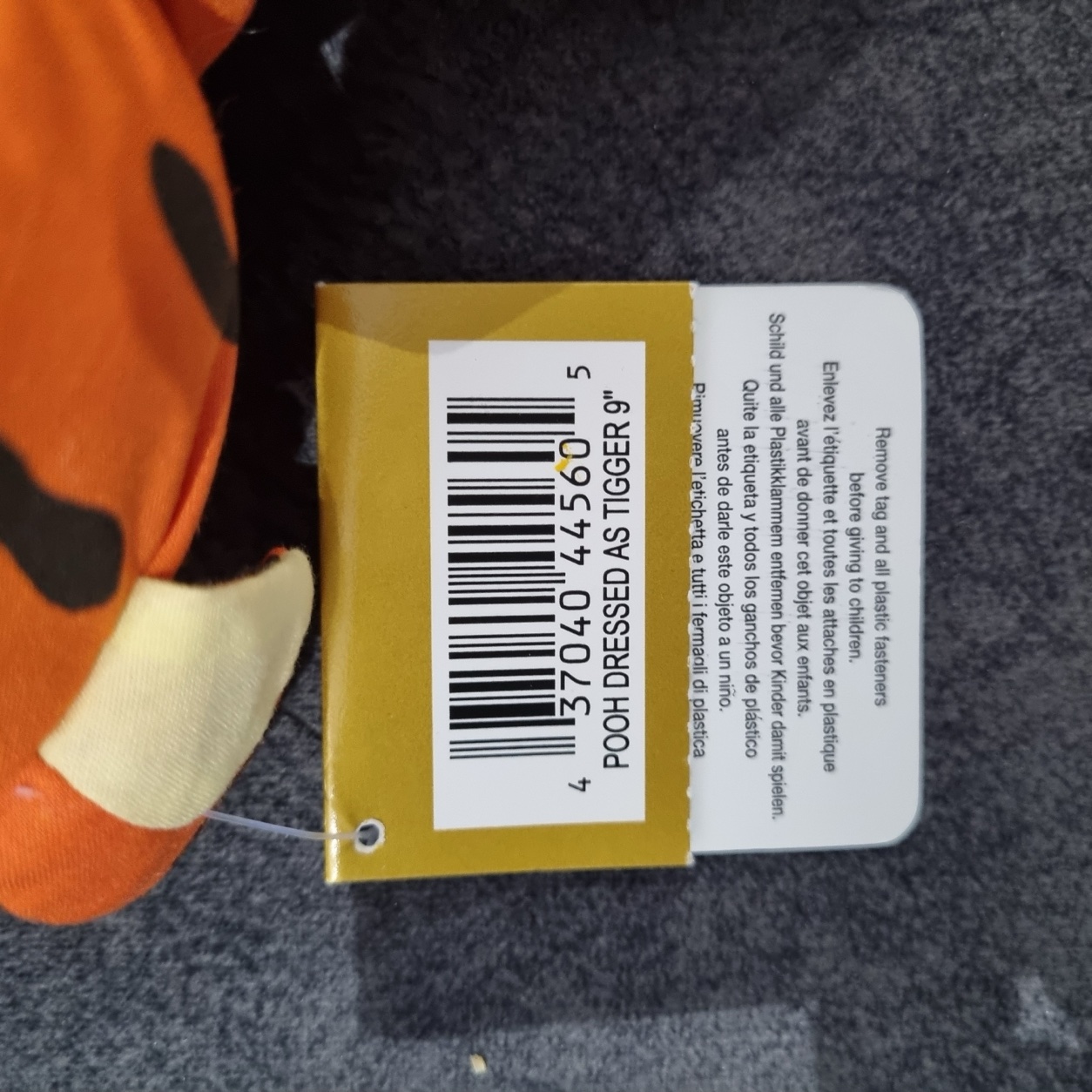 Close-up of the Disney Store gift tag reading Pooh Dressed as Tigger 9 inch, with barcode and care instructions